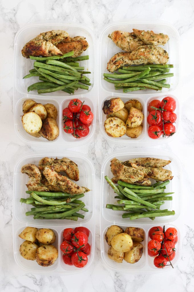 Pesto Chicken meal prep in plastic compartment tubs.